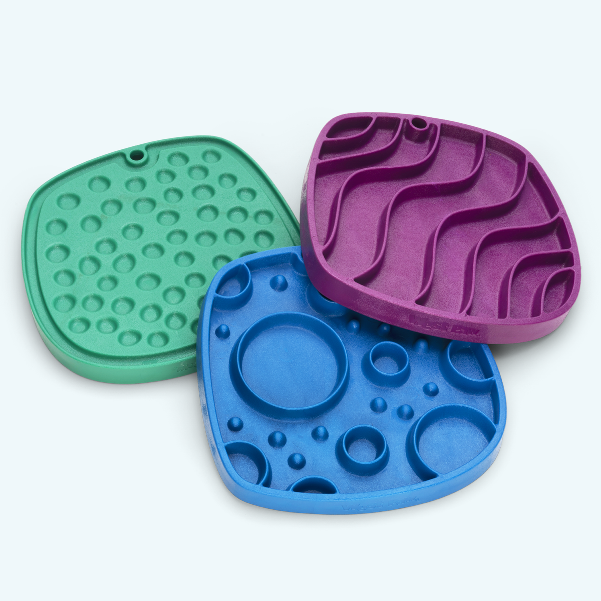 West Paw Bubbles Feast Mats in Kelp, Marine and Tropic Red, showing their textured feeding surfaces.