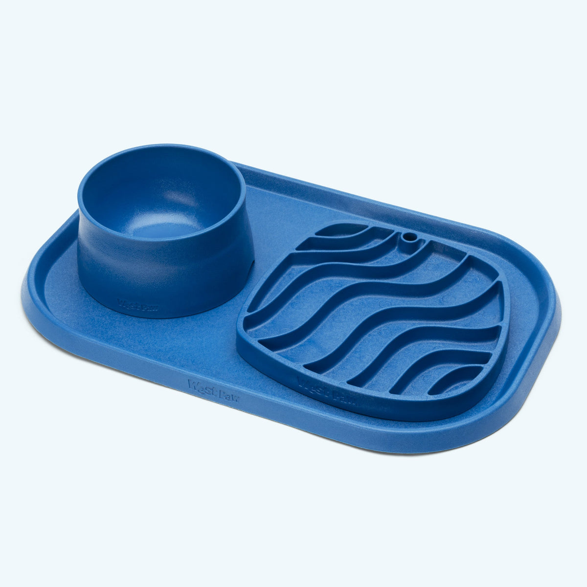 Blue West Paw Non-Slip Bowl beside a matching feeding mat and slow-feeder dish