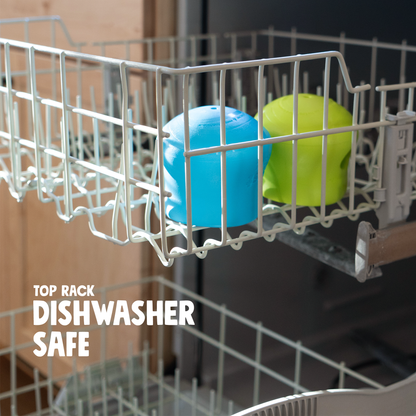 Aqua blue and granny smith Toppl toys in the top rack of a dishwasher